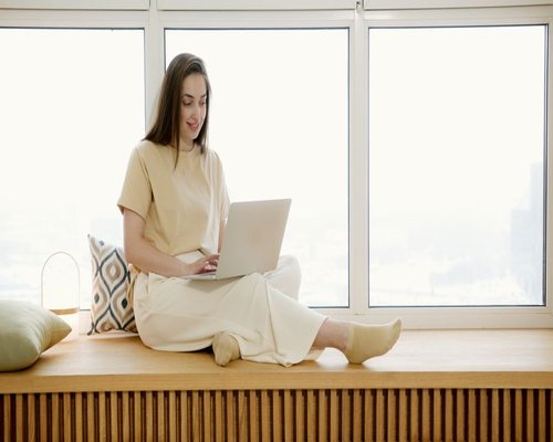 person working comfortably on a laptop beside a bright window with natural light in Mexico City