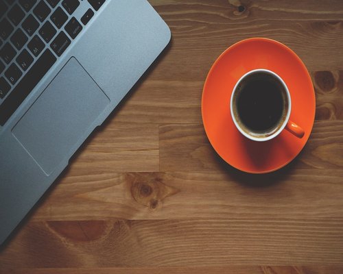 a cup of coffee and an organized desk in a modern coworking space